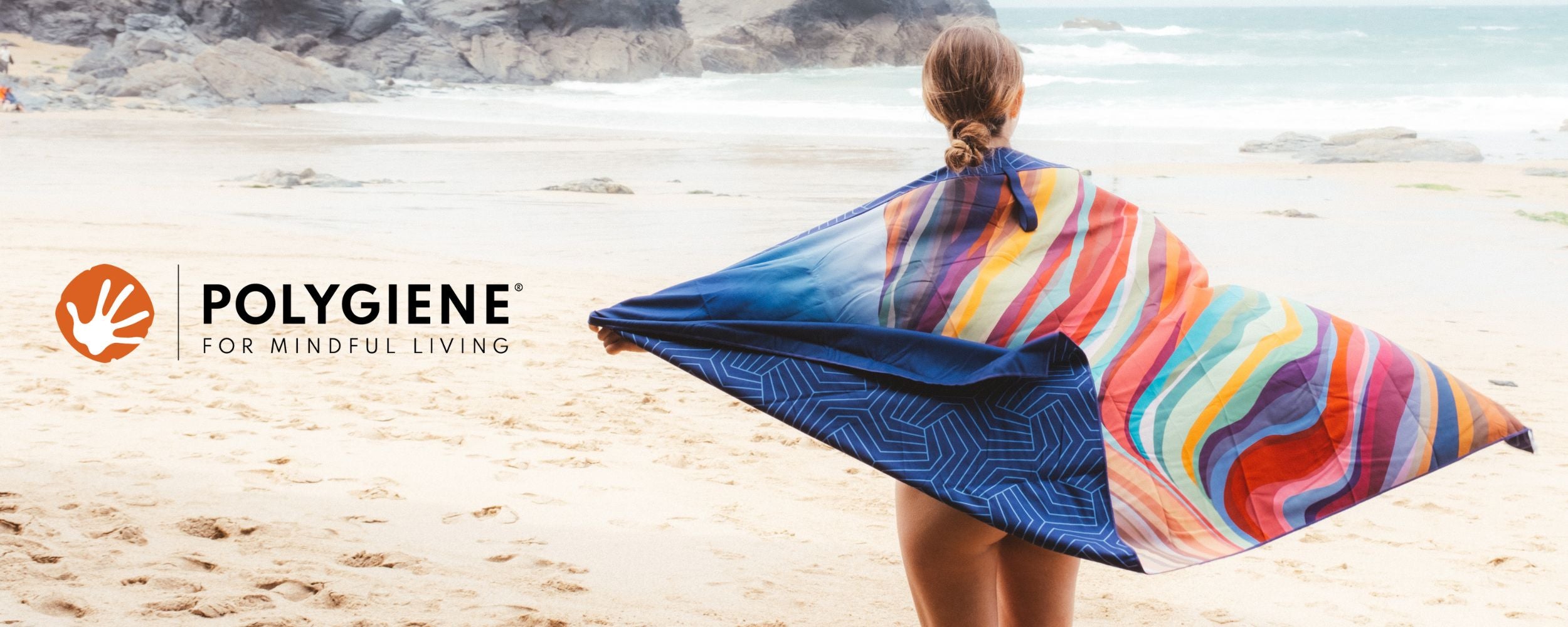 Girl on beach wrapped in Lifeventure Recycled Towel treated with Polygiene StayFresh Technology